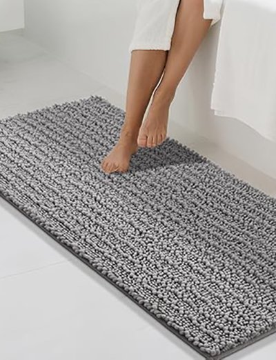 Absorbent chenille bath mat outside tub absorbing water to prevent slips