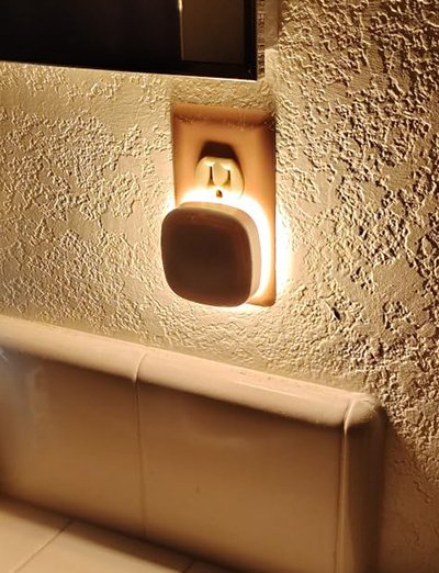 Motion sensor night light illuminating path between bedroom and bathroom